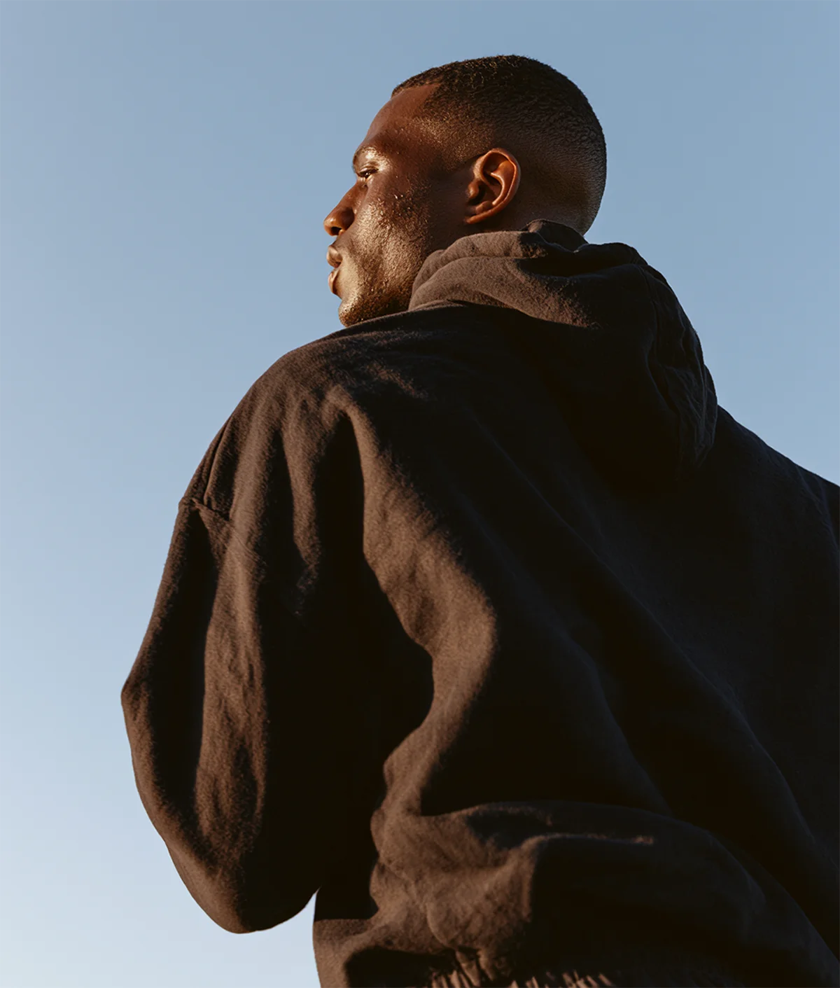 JUUZ - Mann in Hoodie vor Himmel