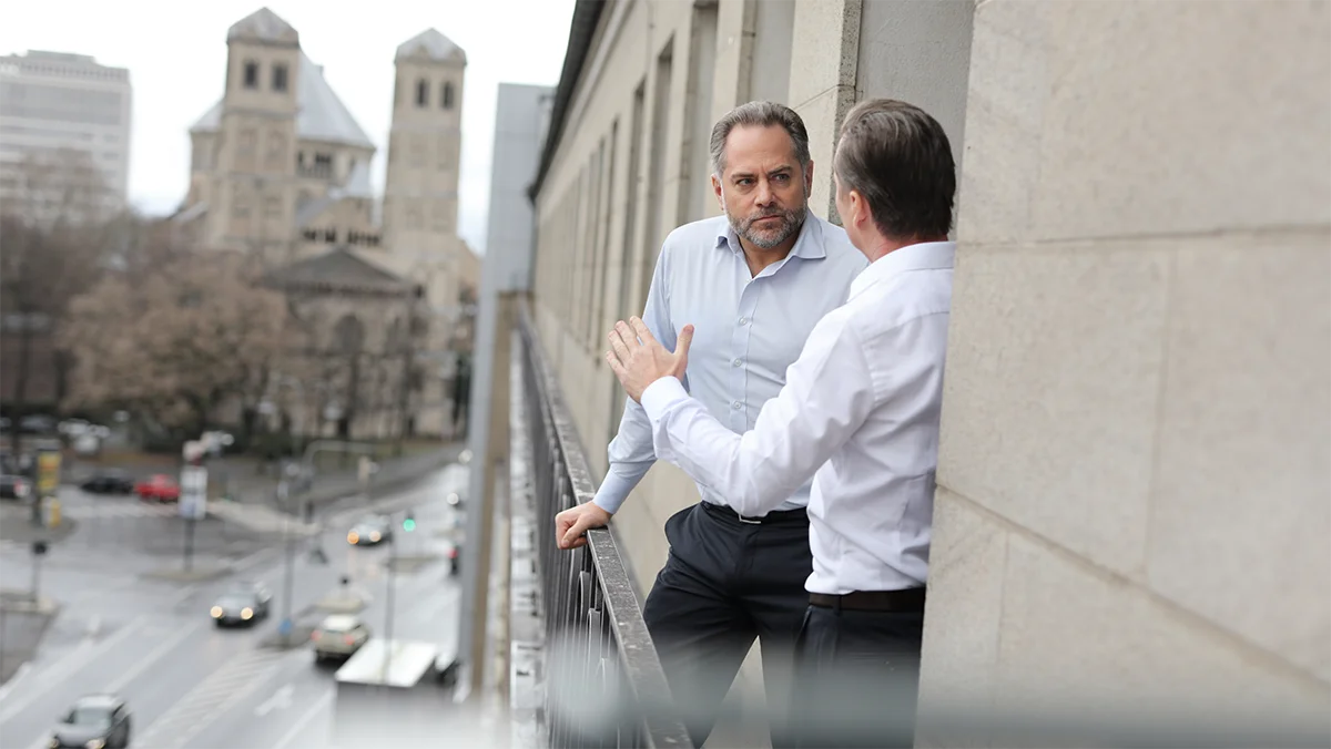 Florett & Falke Lawyers discuss by the window against a city background